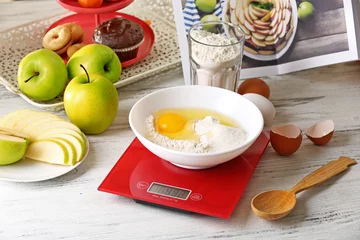 Badkamer foto achterwand Bowl of raw egg and flour with digital kitchen scales on light wooden table © Africa Studio