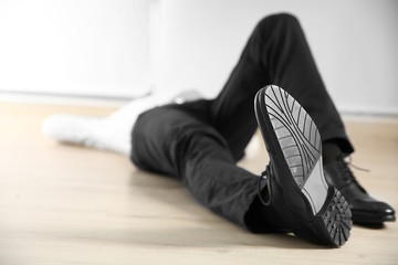Tired businessman lying on the floor