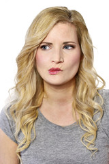 Pensive blond woman looking to the side. Young, toughtful or thinking looking woman,isolated on white.