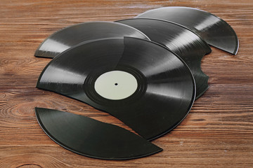 Broken old vinyl records on wooden background