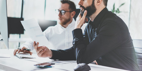 Coworking process photo. Project managers team work new idea.Young business crew working with startup modern office.Desktop computer on table,showing presentation. Blurred,film effect. Wide