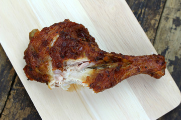 Grilled chicken drumstick on wooden background