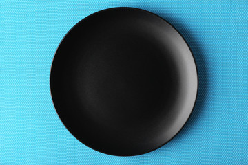 Empty plate on blue textured mat background