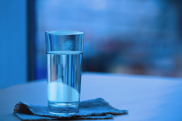 Glass of pure water on blurred background