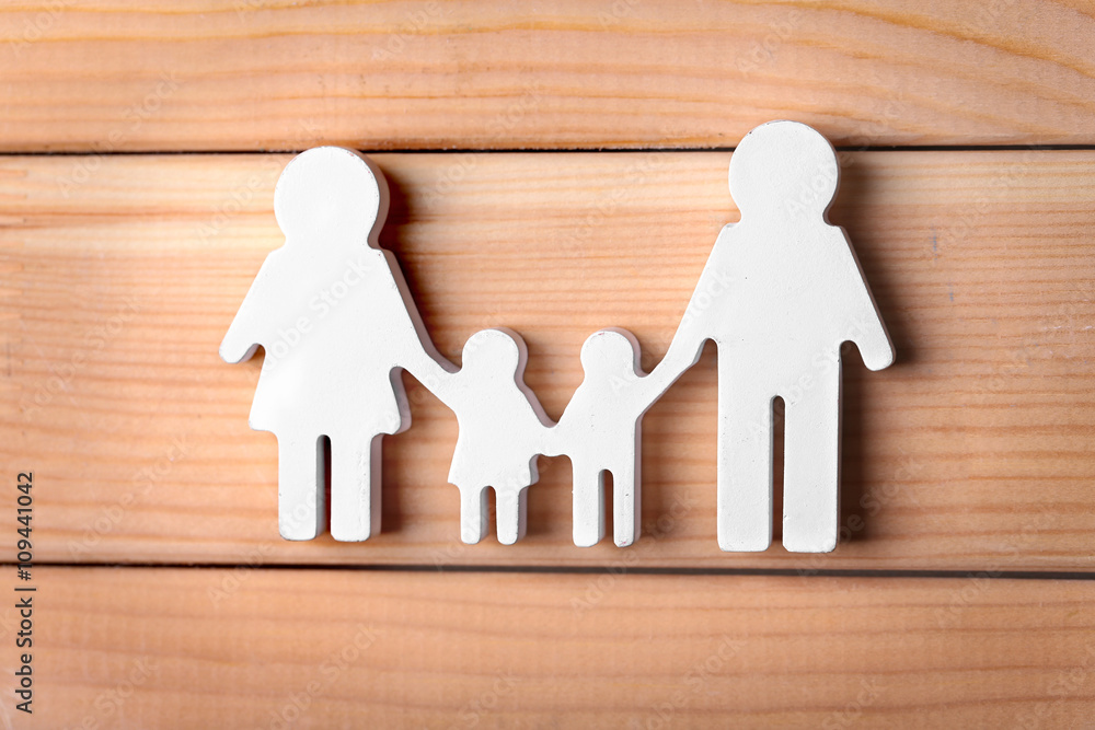 Wall mural Cutout figurine of a family on wooden background