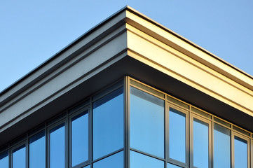 The angle of the top of the building with a cornice and a glass wall.