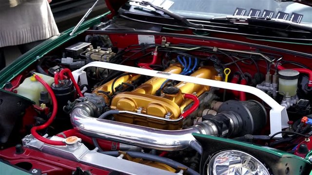 Engine and other parts under hood of vintage sports car, mechanics, maintenance
