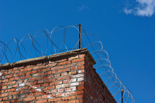 Prison wall with barbed wire.