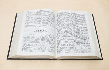 Bible is an open book with text on white paper background on the beige-pink color