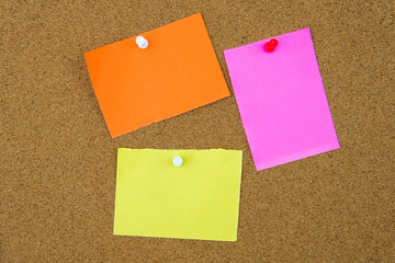 Blank paper notes pinned on cork board
