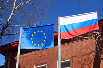 Flags of Russia and European Union waving in wind on street