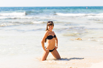 Fototapeta na wymiar Attractive young caucasian woman in swimsuit on the beach.