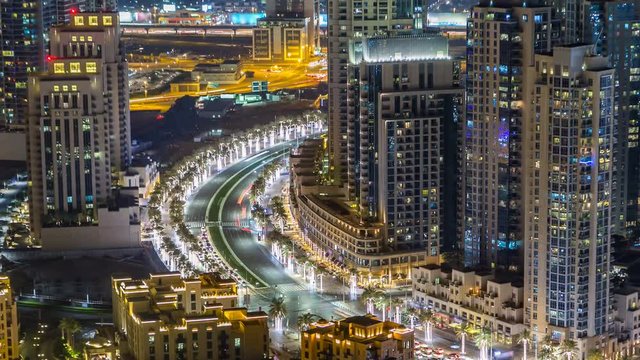 Top view of road in Dubai downtown timelapse with night traffic and illuminated skyscrapers. 