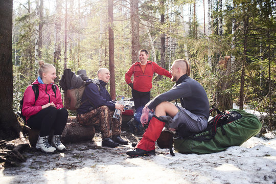 A group of tourists sitting in the forest laughing