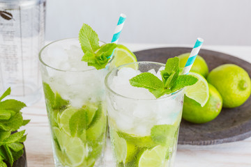Two fresh mojitos cocktail. Mojitos with mint leaves, lime and ice