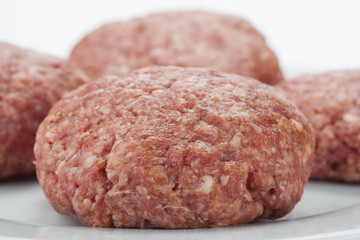 Raw beef burgers against white