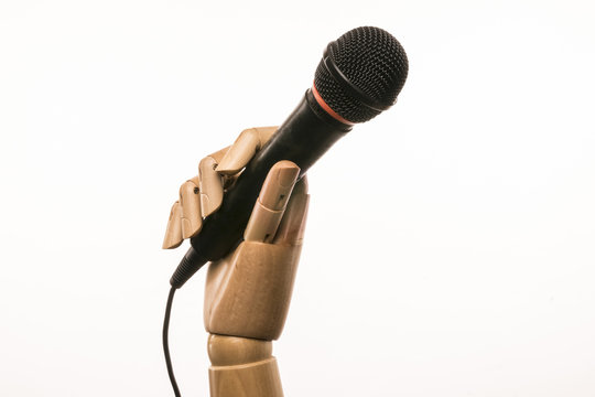 Singer's hand holding a microphone. On white background. With copyspace.