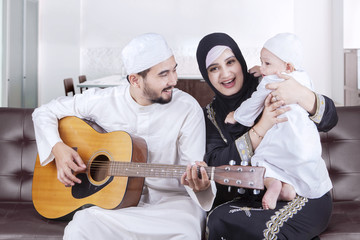 Happy Arabic family playing guitar