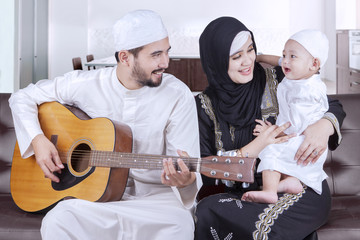 Joyful middle eastern family playing guitar