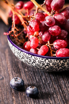 blueberries and red grapes on a wooden background
