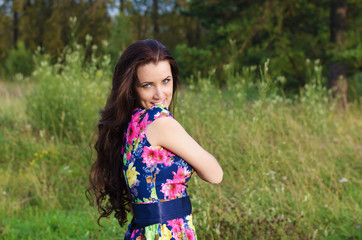 Fototapeta premium Summer portrait of a beautiful woman on nature background
