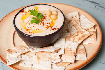 Bol de hummus sobre un plato con pan pita