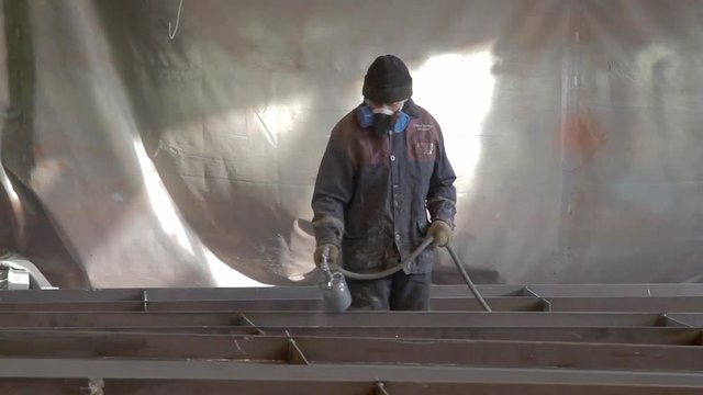 worker is painting a metal beams