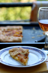 Slice of peach cake and glass of red wine outdoor. Selective focus.