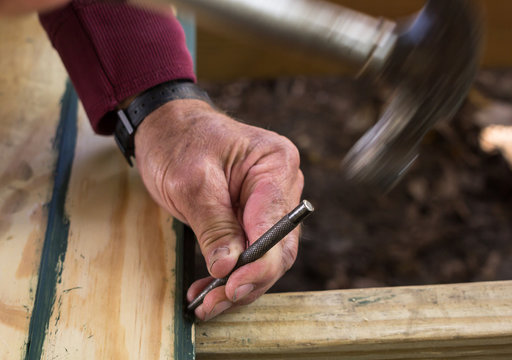Carpenter using nail punch