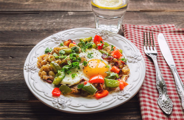 Fried egg with pepper, bacon, potatoes and cilantro