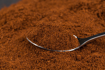 ground coffee and a metal spoon