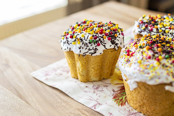 Traditional rustic style Orthodox sweet Easter bread (aka Paskha) topped with sugar glaze on a wooden board