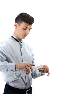 Teenager man waiter pouring water from glass bottle into a glass