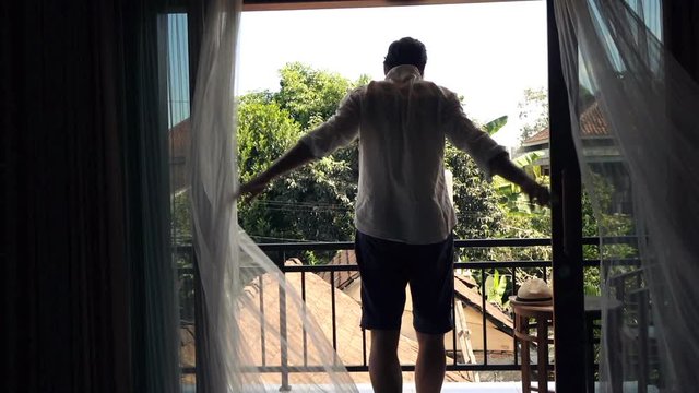 Man unveil curtains and stretching arms on terrace, super slow motion 120fps
