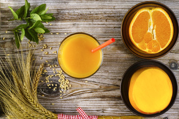 Obraz na płótnie Canvas Healthy fresh pressed mango and orange juice with grains and min