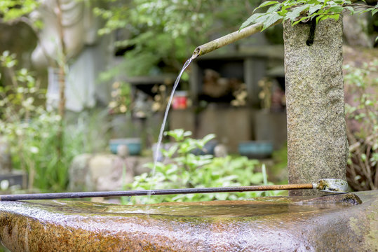 Spout of water at a temple in Japan with dipper © knowlesgallery