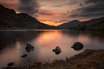 Three stones on quiet Loch Eck in sunset light, Scotland