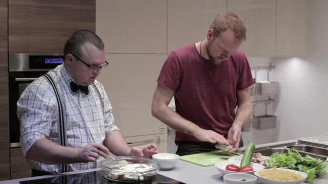 The men in the kitchen preparing fish steaks