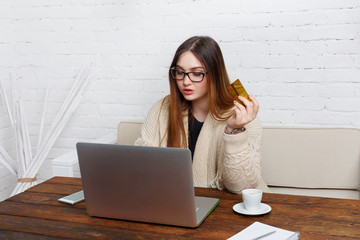 Young woman in glasses online shopping at home