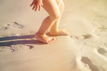 little girl feet play on beach