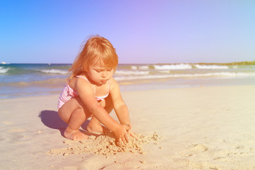 little girl play with sand on beach