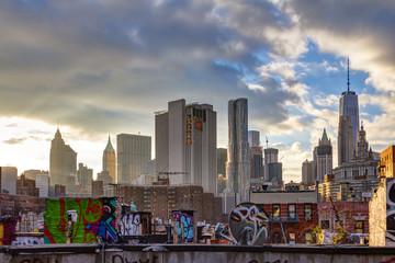 Sunlight shines on lower Manhattan buildings at sunset in New York City - obrazy, fototapety, plakaty