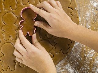 cropped view of woman's hand using cookie cutter