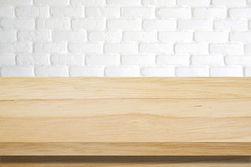 Empty wooden table over white brick wall background