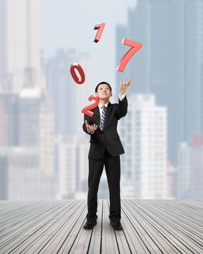 Businessman catching throwing 2017 red words