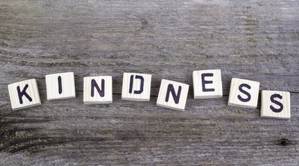 Fototapeta premium Text: Kindness from wooden letters on wooden background