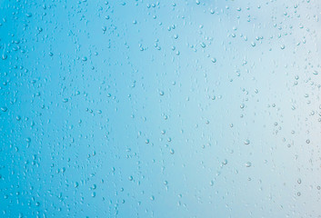 Rain drops on window surface, blue gradient shade