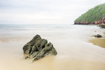 Long exposure shot on beach, selective focus, focus on rock