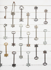 Some door keys aligned on old wooden surface, safety and security concept background