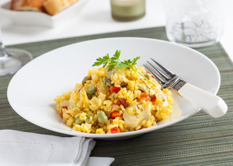 A plate of rice with vegetables and saffron.